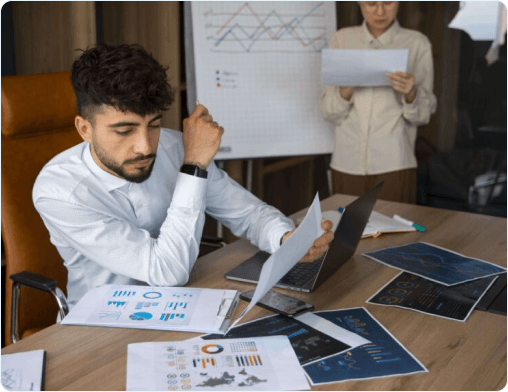 Accountant reviewing financial reports at a desk with charts in the background