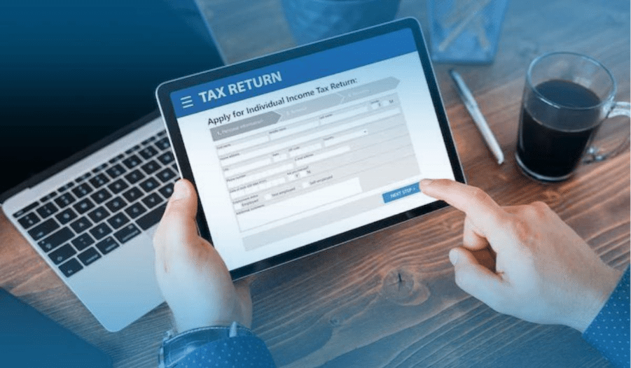 Tax professionals in a meeting reviewing documents and a laptop